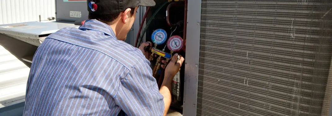 HVAC technician servicing a condenser unit in Oak Bluffs
